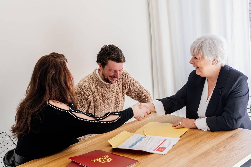 huurder en verhuurder schudden handen bij ondertekenen van huurcontract