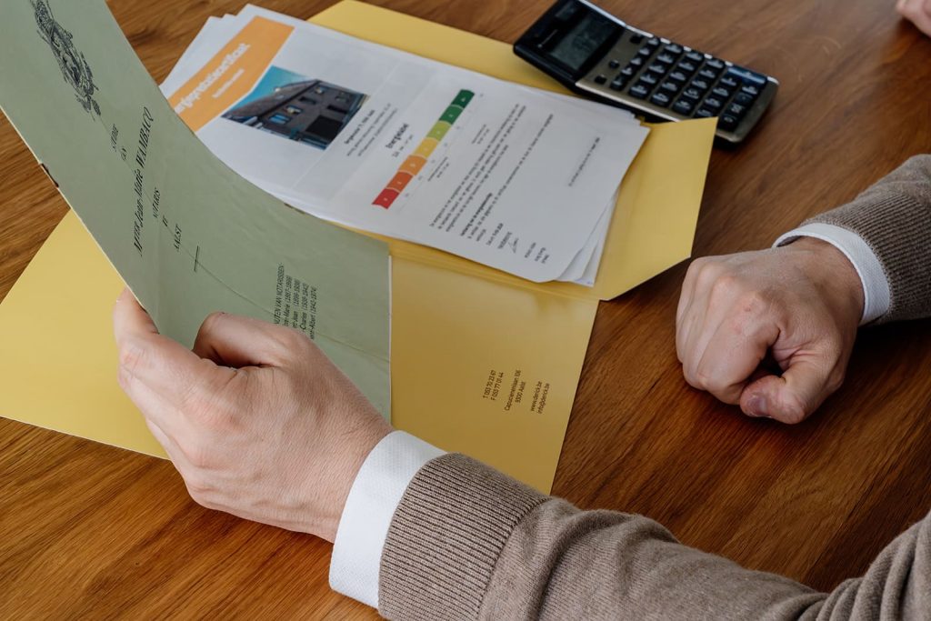 financiële documenten en attesten controleren bij woning verkopen aan tafel