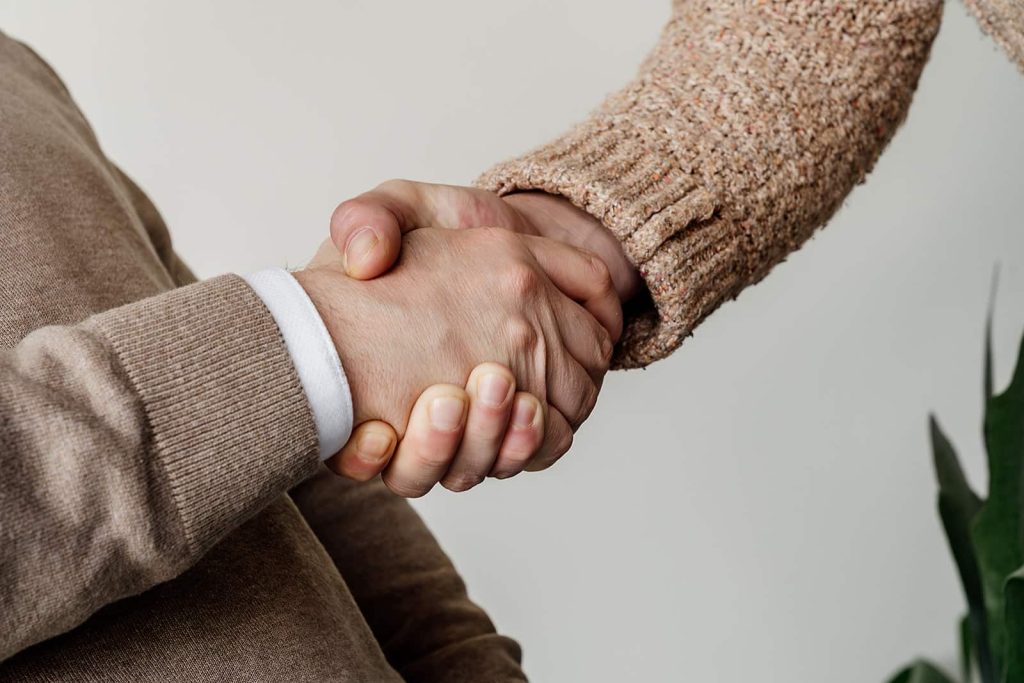 Handdruk tussen twee mensen na overeenkomst met gegarandeerd geld op de rekening