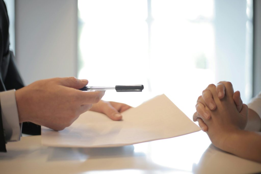 Persoon tekent contract met pen voor snelle verkoop en geld op de rekening